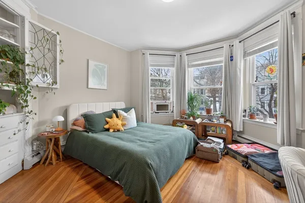 a bedroom with a bed and wooden floor