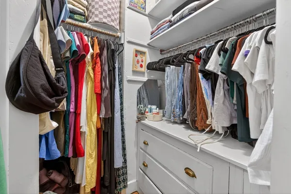 a view of walk in closet with clothes