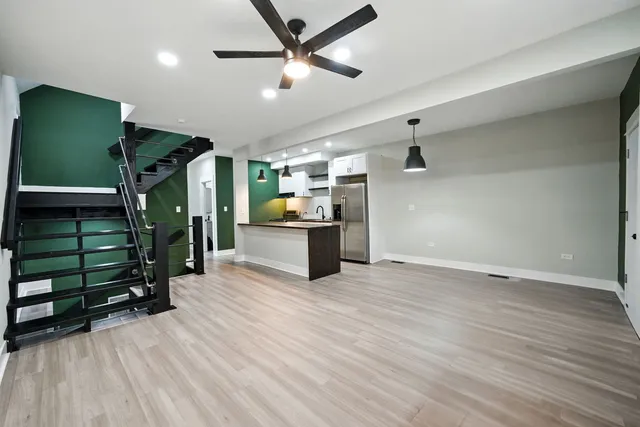 an empty room with wooden floor closet fan and windows