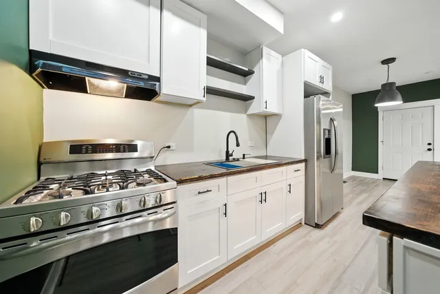 a kitchen with stainless steel appliances granite countertop a stove a sink and a refrigerator