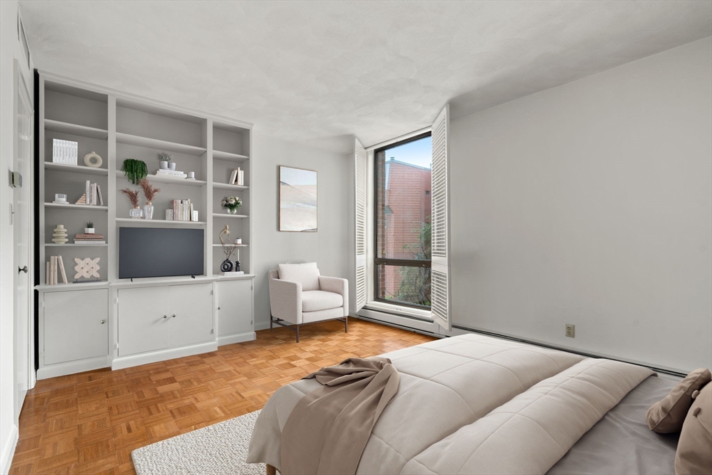 75 Grove Street, Unit 227 Wellesley, MA 02482 - Photo 22 of 29 a bedroom with a large bed and a flat screen tv