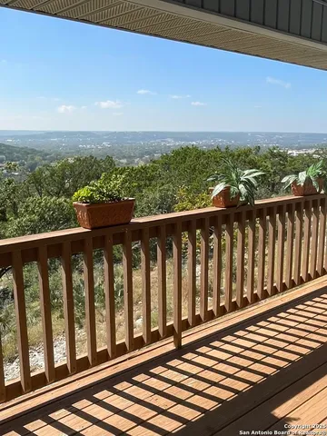 a view of a balcony with wooden floor and fence