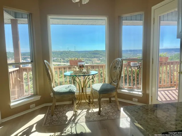 a view of a living room with a large window and dining table