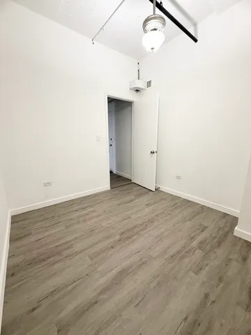 an empty room with wooden floor and cabinet