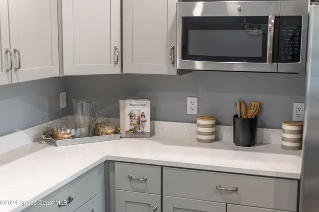 a kitchen with a microwave a sink and cabinets