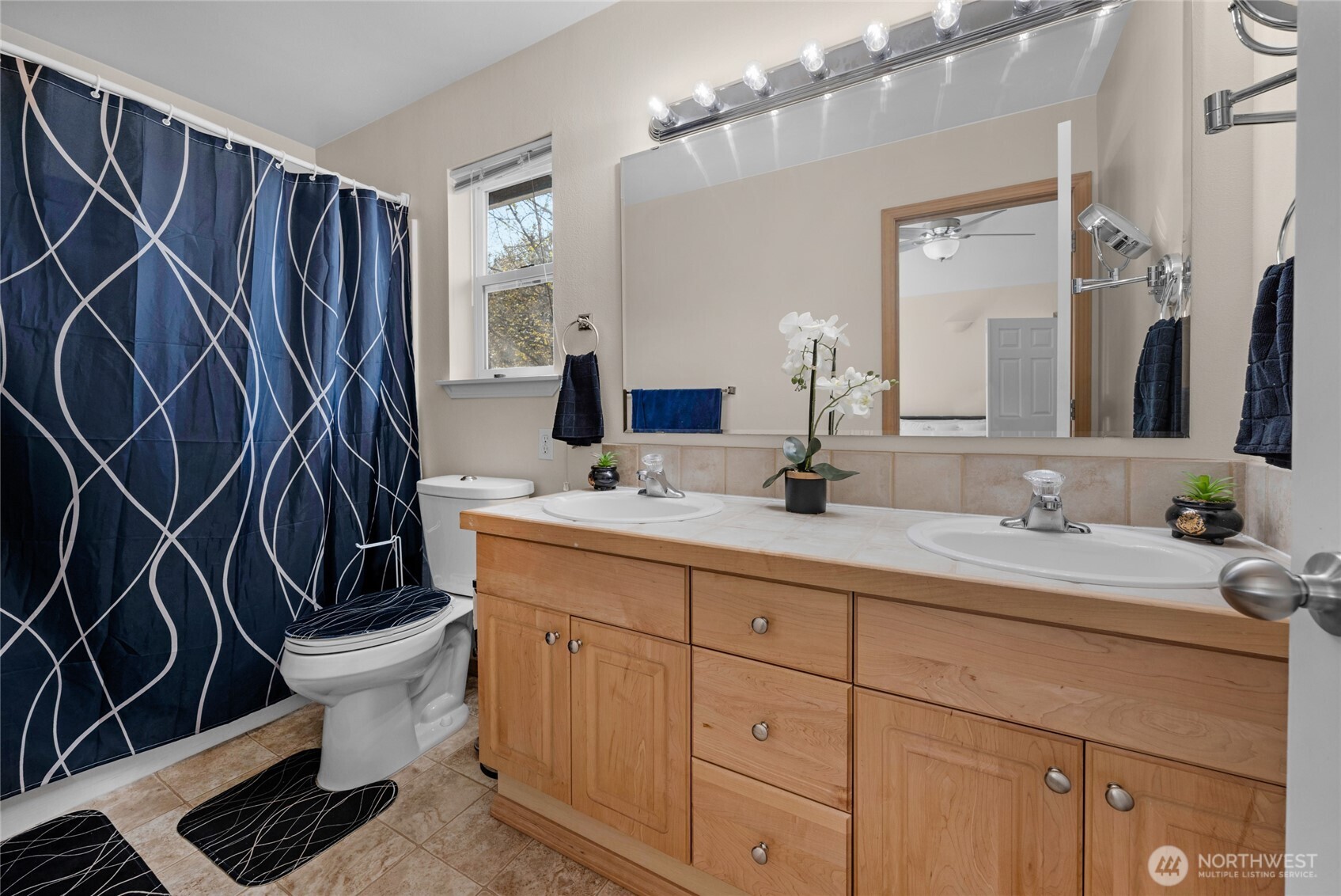 11628 50th Drive Southeast Everett, WA 98208 - Photo 19 of 37 a bathroom with a sink a toilet a mirror and shower curtain