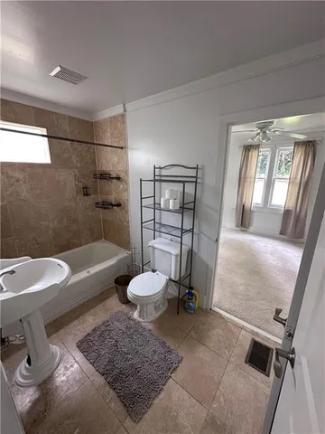 a bathroom with a tub sink toilet and a rug