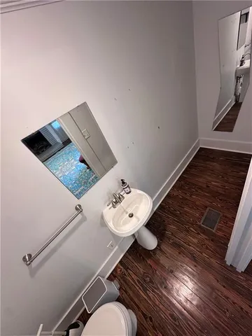 a bathroom with a sink mirror and toilet