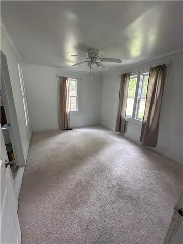 a view of a livingroom with a ceiling fan and window