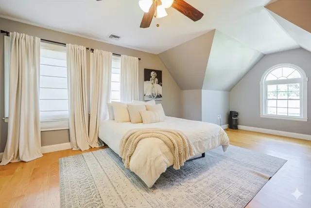 a spacious bedroom with a large bed and a chandelier