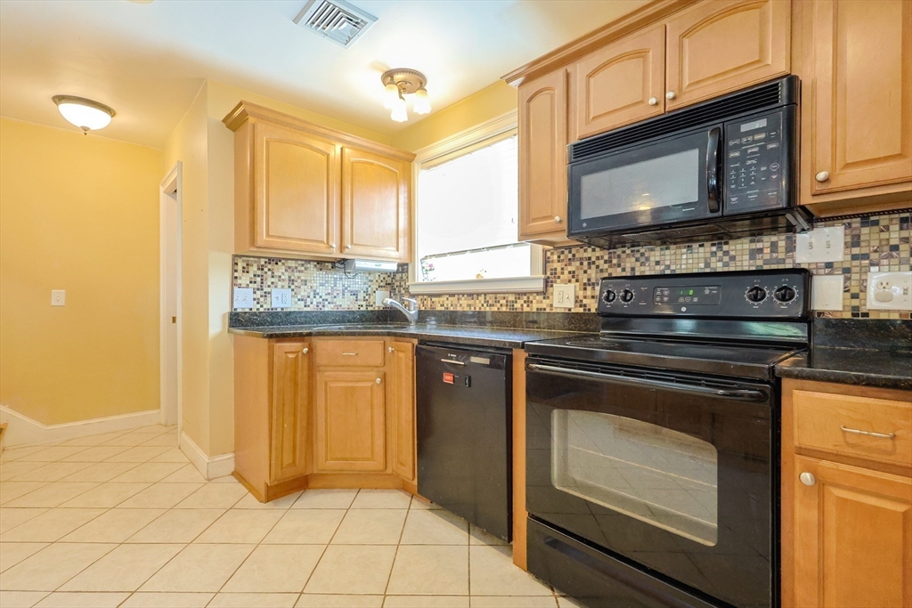 8 A Whitins Road Sutton, MA 01590 - Photo 4 of 26 a kitchen with granite countertop a stove a sink and a microwave