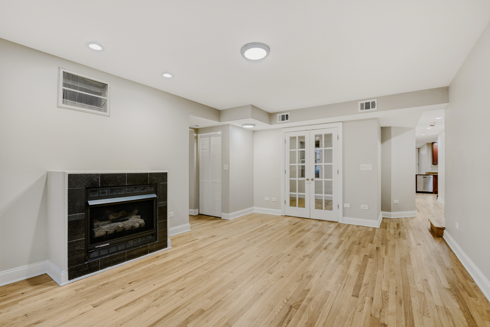 6450 North Bell Avenue, Unit G Chicago, IL 60645 - Photo 5 of 18 a view of an empty room with wooden floor fireplace and a window