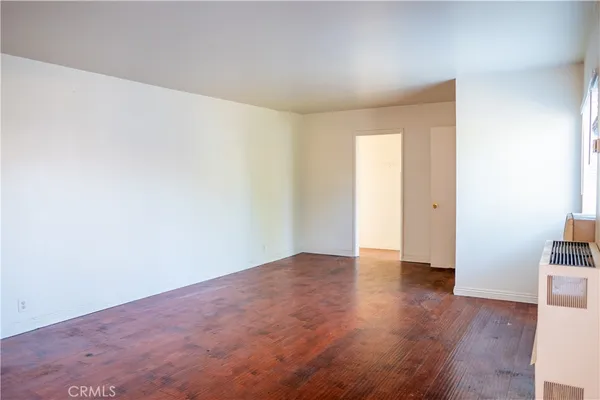 an empty room with wooden floor and shelves