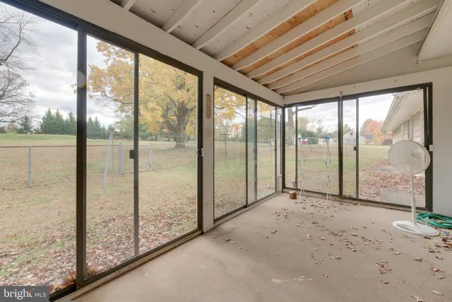 a view of an empty room with wooden floor and iron stairs