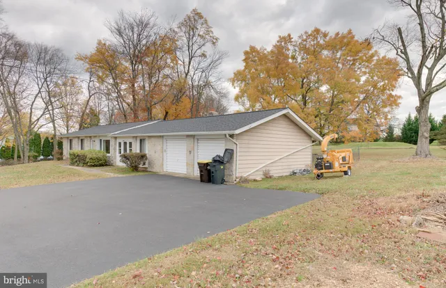 a view of a house with a yard and large tree