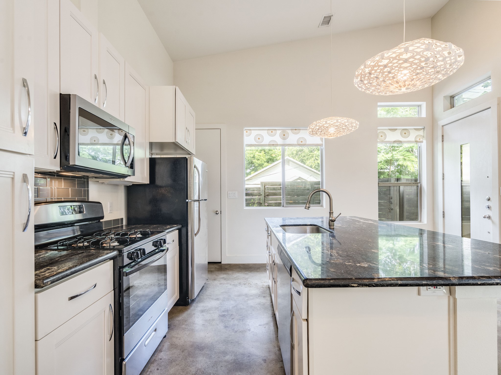 1404 Singleton Avenue, Unit B Austin, TX 78702 - Photo 6 of 21 Culinary delights await in this bright kitchen with modern pendant lights and a functional center island.
