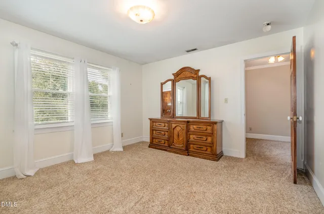 a view of an empty room with window and cabinet