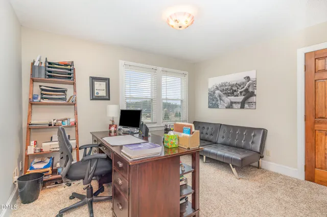 a view of a workspace with furniture and a window