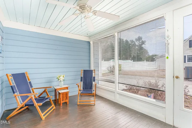 a view of a patio with table and chairs and floor to ceiling window with wooden floor