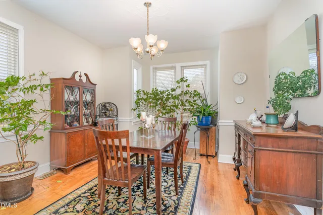 a dining room filled chandelier and wooden floor