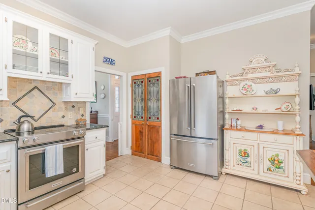 a kitchen with stainless steel appliances a stove a refrigerator and cabinets