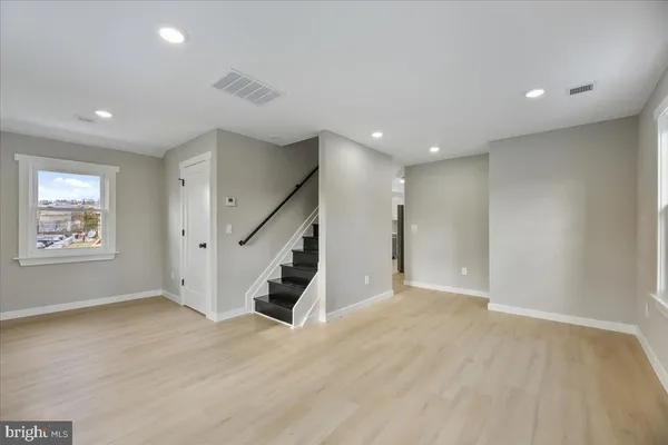 an empty room with wooden floor and entryway