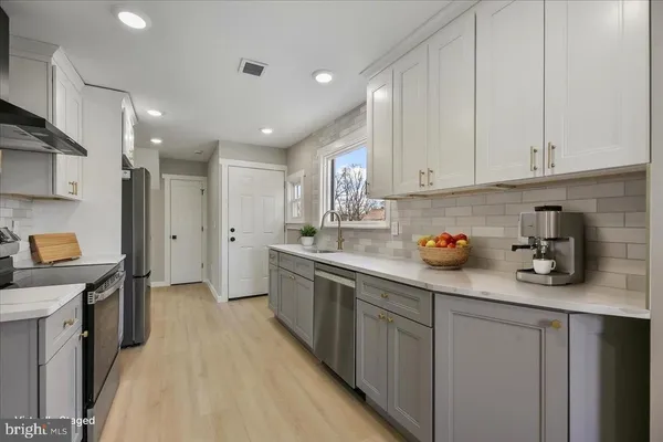 a kitchen with white cabinets and sink