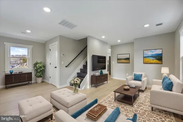a living room with furniture and wooden floor