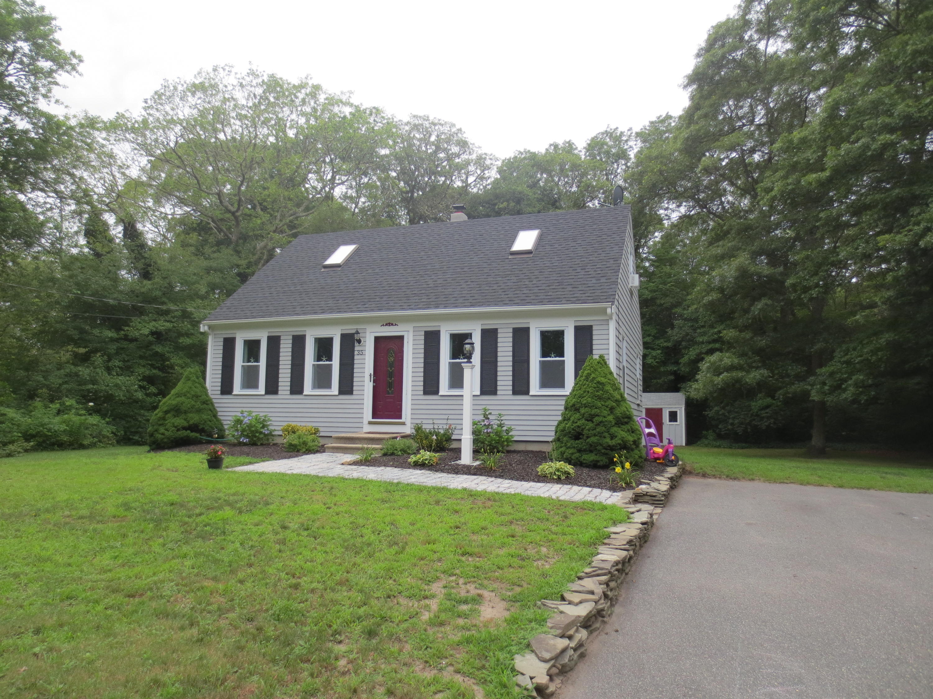 35 Stage Coach Road Centerville, MA 02632 - Photo 1 of 29 a front view of a house with a yard and garage