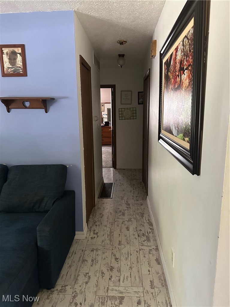 15528 Stoltz Road Diamond, OH 44412 - Photo 11 of 28 Hallway with a textured ceiling and light tile patterned floors