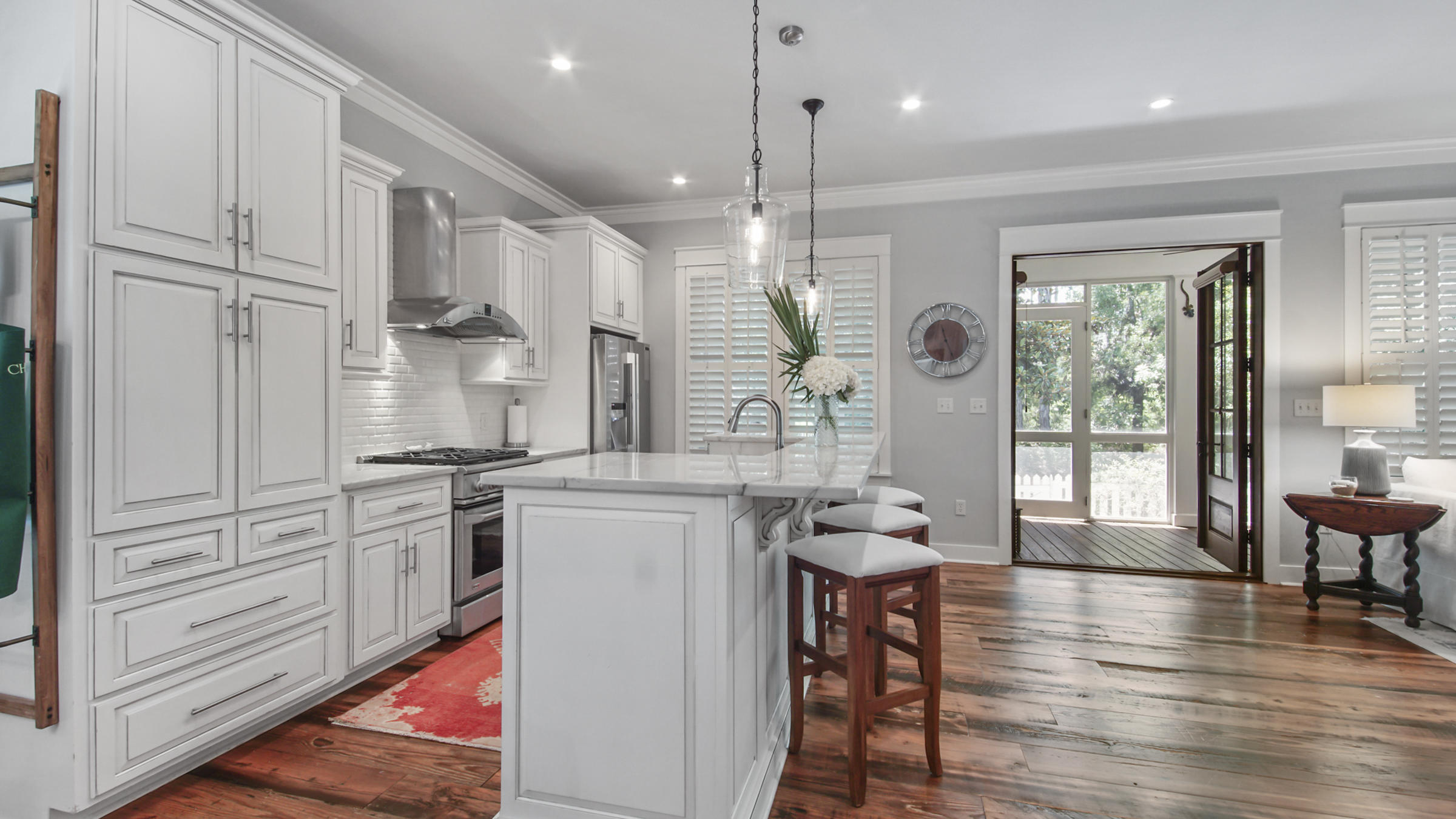 247 Artesian Way Watersound, FL 32461 - Photo 7 of 36 a kitchen with granite countertop a stove a sink a dining table and chairs