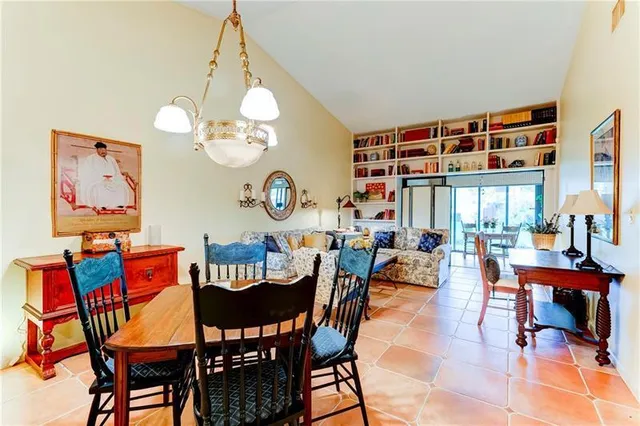 a view of a dining room with furniture a chandelier and a large window