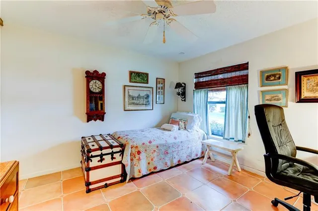 a bedroom with a bed a baby desk and chair next to a window