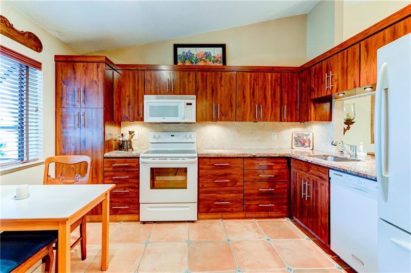 3342 Carambola Circle South Coconut Creek, FL 33066 - Photo 3 of 17 a kitchen with stainless steel appliances granite countertop a sink stove and cabinets