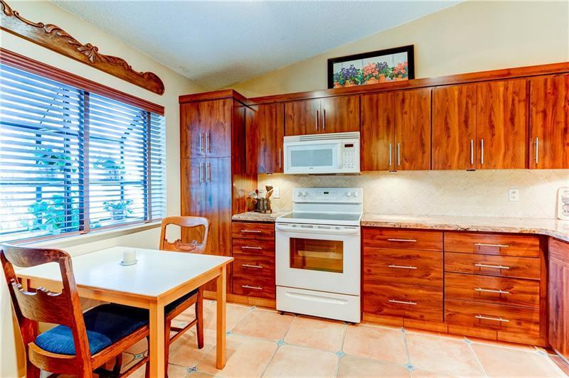 3342 Carambola Circle South Coconut Creek, FL 33066 - Photo 8 of 17 a kitchen with stainless steel appliances granite countertop a stove a sink and a refrigerator