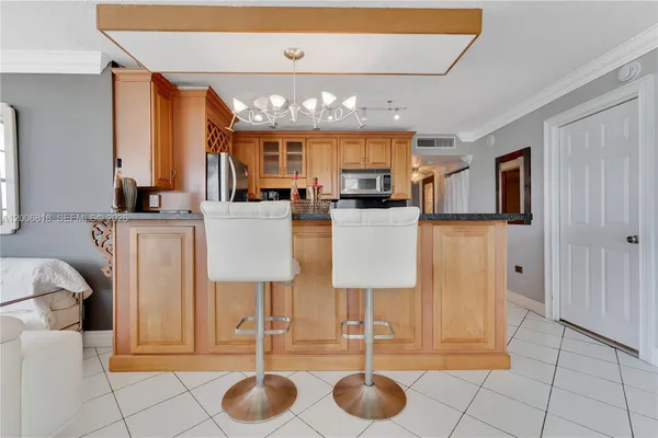 a kitchen with stainless steel appliances kitchen island granite countertop a table and chairs in it