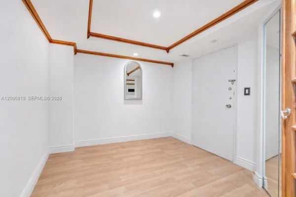 a view of a room with wooden floor and white walls