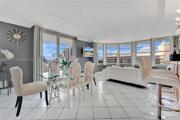 a dining room with furniture and a floor to ceiling window