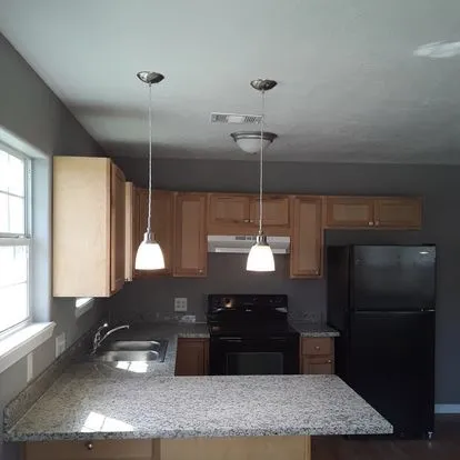 a kitchen with a sink a refrigerator and window