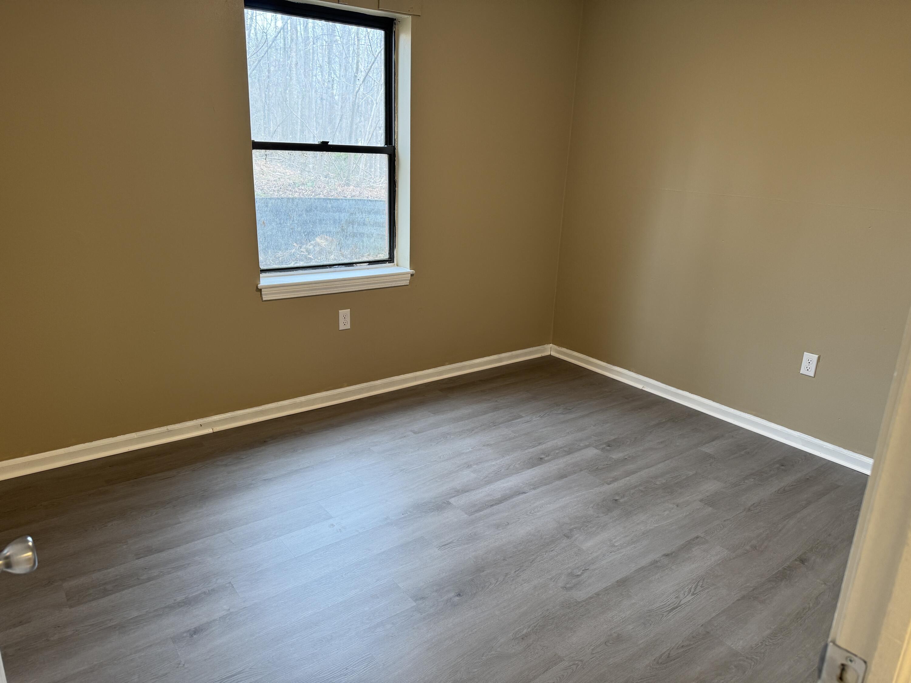 45 Vera Avenue, Unit 4 Collinsville, VA 24078 - Photo 7 of 8 an empty room with wooden floor and windows