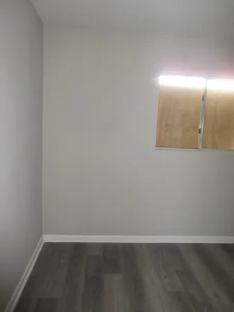 an empty room with wooden floor and mirror