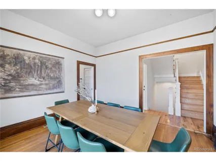 a living room with a table and paintings on the wall