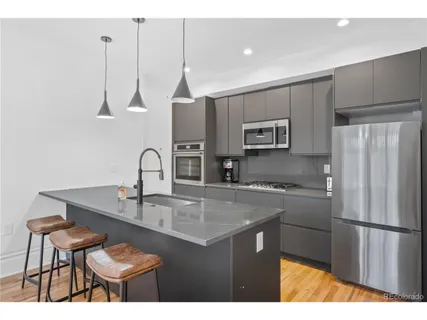 a kitchen with kitchen island a counter space a sink appliances and cabinets