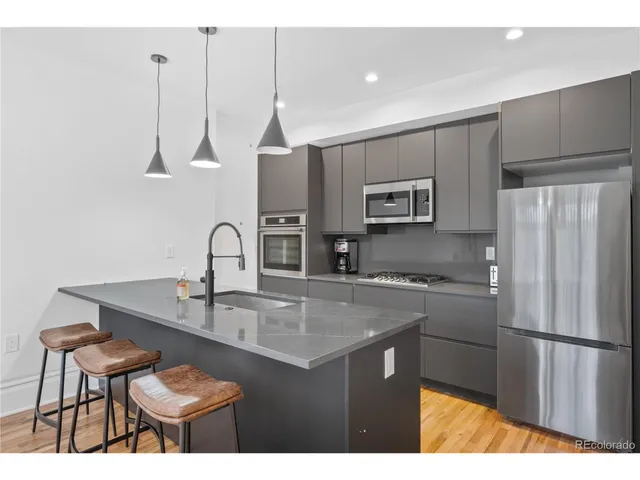 a kitchen with kitchen island a counter space a sink appliances and cabinets