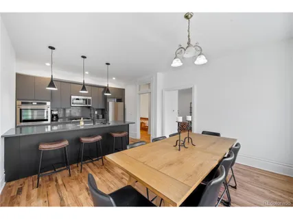 a kitchen with a table chairs and wooden floor