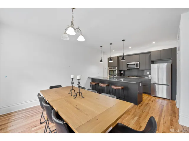 a kitchen with a table chairs and refrigerator