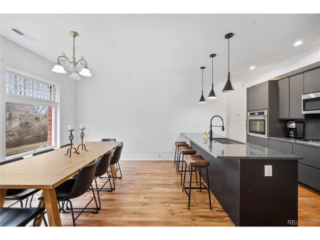 a dining room with furniture a chandelier and wooden floor