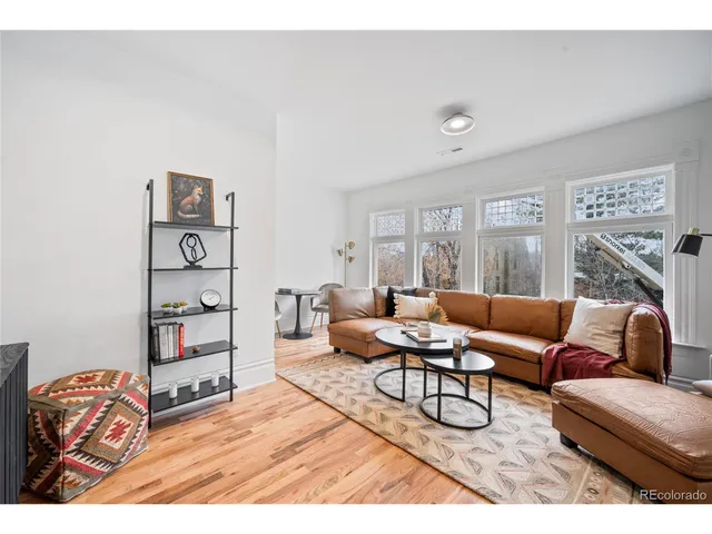 a living room with furniture a rug and white walls