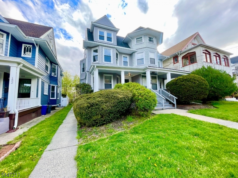 a front view of a house with a yard and potted plants