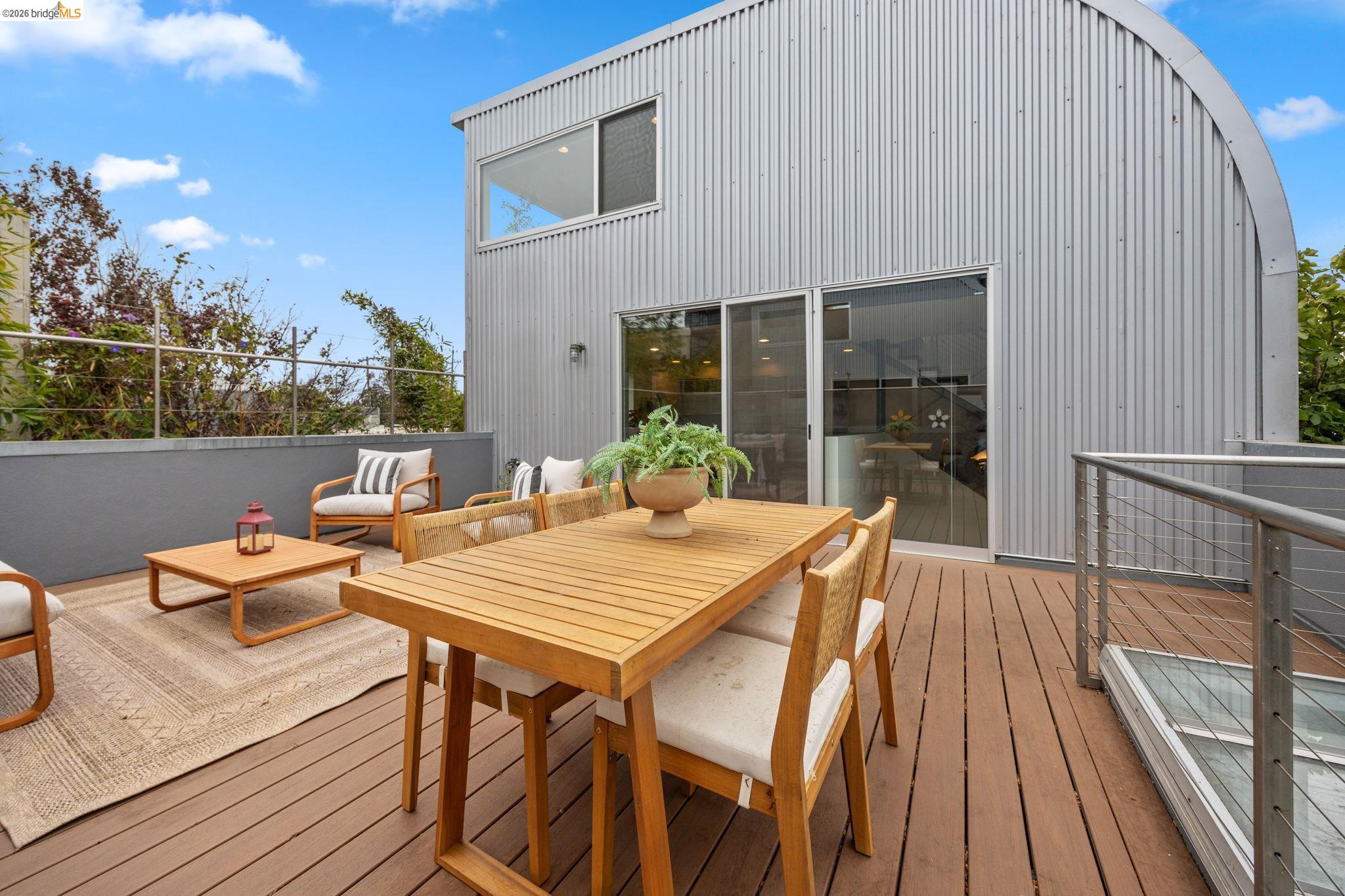 2709 Tenth Street, Unit D Berkeley, CA 94710 - Photo 17 of 29 Expansive outdoor deck with wood-finish flooring, featuring a cable railing system, and direct access to interior spaces through sliding glass doors